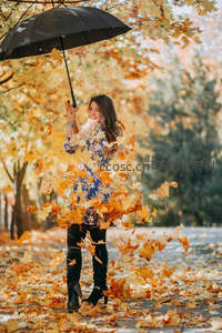 秋日落叶纷飞，女子撑伞笑颜如花