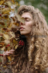 秋日卷发女子与落叶的静谧瞬间