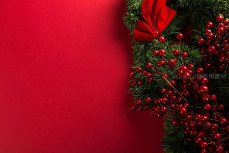 红色背景上的圣诞花环与浆果特写