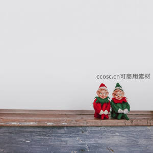 两个小精灵玩偶坐在木质台面上