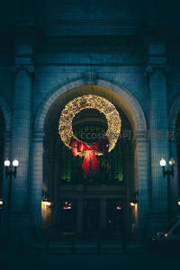 夜幕下宏伟建筑前的璀璨圣诞花环