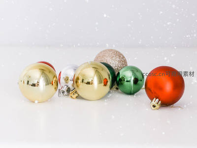 多彩圣诞球散落雪地，缤纷喜庆