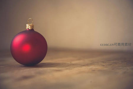 红色圣诞球静置于木桌之上