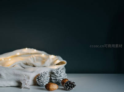 松果与暖灯点缀的冬日静谧桌面布置
