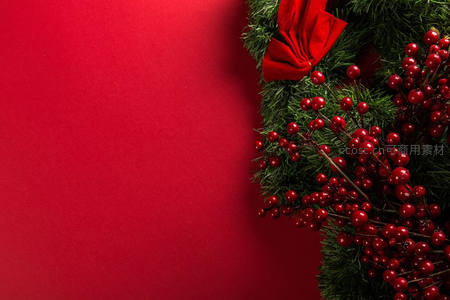 红色浆果圣诞花环点缀纯红背景角落
