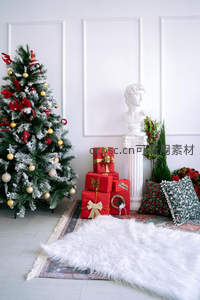 圣诞树旁堆叠的红色礼物与白色雕塑