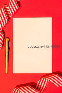 红色背景上的空白卡片与金色笔