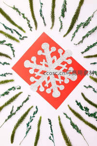 红色背景上的银色雪花与绿色松枝装饰