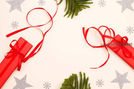 红色礼盒丝带与松枝点缀的节日构图