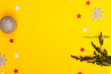 明亮黄色背景上的圣诞装饰与松枝