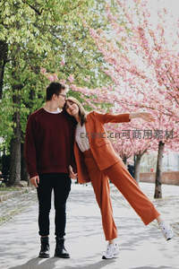 情侣在樱花树下甜蜜互动