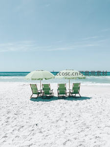 白色沙滩上两把遮阳伞与躺椅