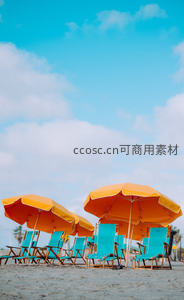 沙滩上橙色遮阳伞与蓝色躺椅静待游客
