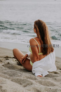 沙滩碧海旁，女子静坐凝望远方