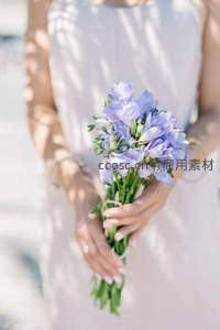 新娘手捧淡紫小花束，阳光洒落温柔瞬间