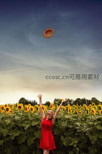 红裙女子在向日葵田抛起帽子迎接夕阳