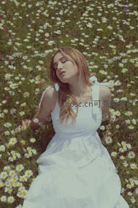 白裙少女静卧雏菊花海闭目享受自然