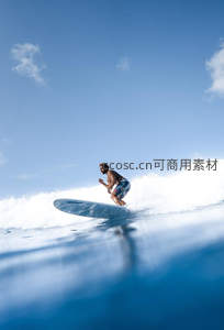 冲浪者在碧海蓝天中驾驭巨浪