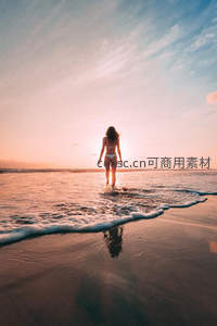 夕阳下女子漫步海滩剪影美景
