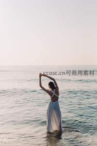 海边女子背影舒展双臂拥抱大海