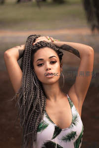 棕发辫女郎户外摆拍，自信迷人姿态