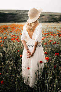 白衣女子背对镜头凝望花田