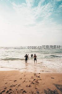 三人奔向海浪的沙滩背影