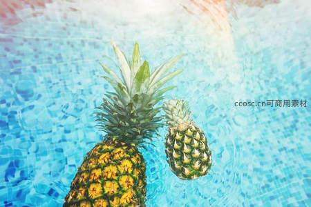 泳池中的菠萝特写，热带风情扑面而来