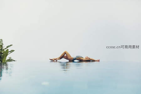 无边泳池中女子漂浮享受宁静时光