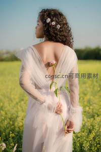 花海中的少女背影，手持玫瑰凝望远方