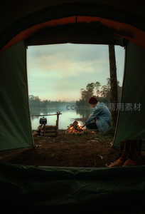 帐篷内视角，湖边篝火映衬黄昏美景
