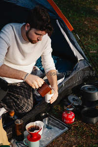 帐篷内专注手冲咖啡的男子