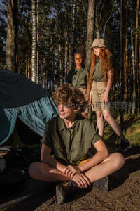 森林营地：青少年在树影下休憩谈笑