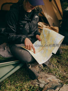 帐篷内专注研究地图的女探险者