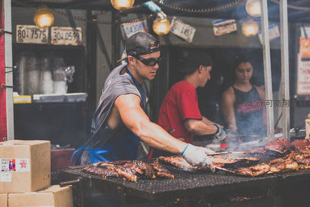 烧烤师傅挥汗如雨，烤架上肉香四溢