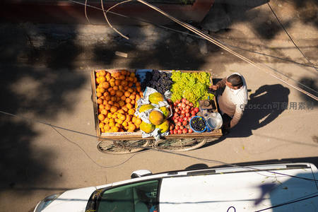 俯瞰水果车小贩，阳光下色彩斑斓果香满街