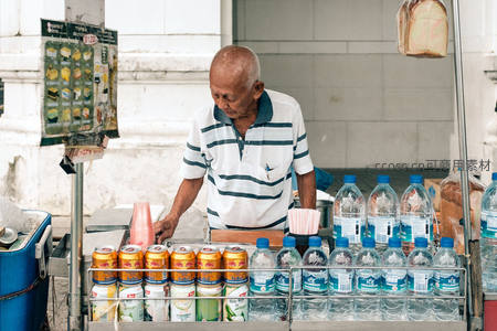 白发老人守摊售卖饮料，冰镇罐装水整齐陈列