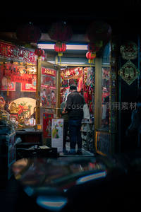 夜市灯笼下的传统店铺，顾客正在挑选商品