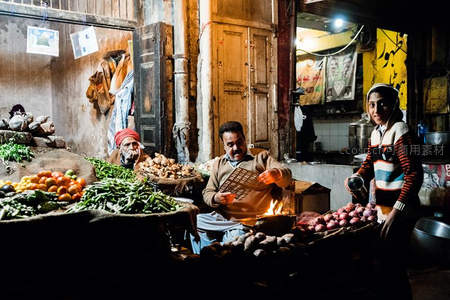 夜市灯火中烤肉摊主忙碌身影