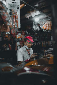 昏暗杂货铺里专注工作的店主
