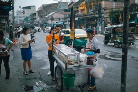 雨后街头，游客排队购买泰式街头小吃
