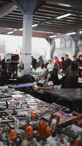 旧货市场里专注翻阅的老者身影