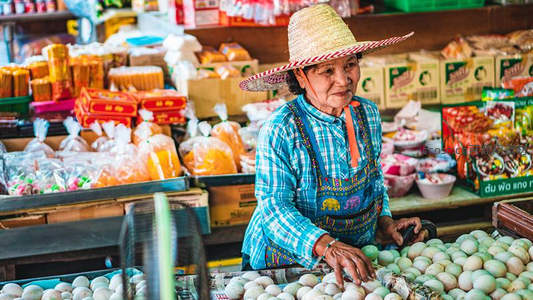 市场摊主专注挑选新鲜禽蛋