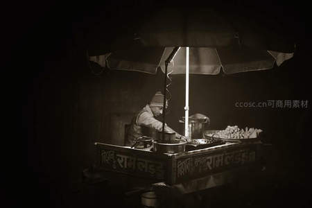 夜市灯下的小吃摊贩剪影