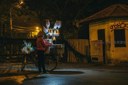 夜色中卖糖葫芦的小贩推车前行