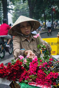 斗笠花贩路边卖玫瑰，色彩鲜艳引人驻足