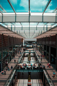 现代购物中心玻璃穹顶下人流穿梭如织