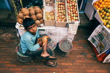 小男孩守护着水果摊的宁静