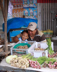 父子档菜摊温馨笑容满溢市场