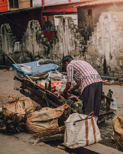 街头菜贩整理满载蔬菜的手推车